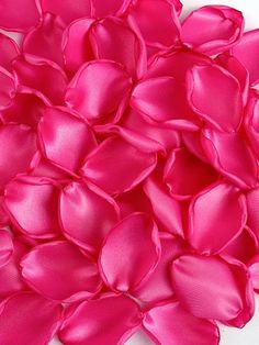 a pile of pink satin flowers on a white surface