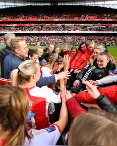 the women's soccer team is all congratulated by their coach on the field