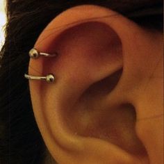 an ear with three piercings attached to it