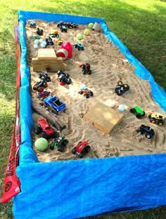 an outdoor play area with toys and sand in the shape of a truck on it