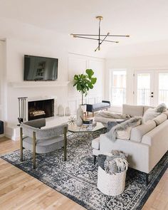 a living room with white furniture and a fireplace