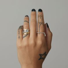 a woman's hand with two different rings on her fingers and one holding the other