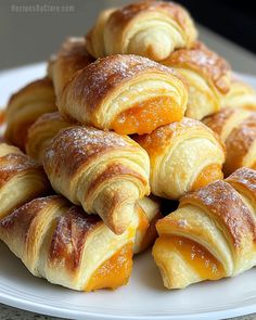 a pile of croissants sitting on top of a white plate covered in powdered sugar