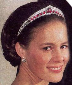 a woman wearing a tiara and smiling at the camera