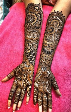 two hands with henna tattoos on them