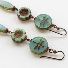 Beaded Czech Glass Dangle Earrings Fly away in style with these unique Dragonfly Flower Dangle Earrings. Featuring dreamy seafoam opaline Czech glass beads. Perfect for any nature lover, these earrings will have you buzzing with joy. Handmade with copper wire. 2.75 inches long Niobium Hypoallergenic Ear wires SKU #EAR021 Handmade in Maine Limited Edition Czech Beads Jewelry, Jewelry To Make, Czech Glass Jewelry, Beaded Jewelry Earrings, Flower Dangle Earrings, Bead Projects, Stacked Earrings, Pretty Beads, Earring Designs