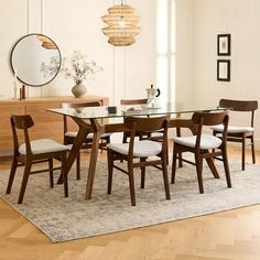 a dining room table and chairs with a rug on the floor in front of it