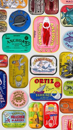 an assortment of tins that are all different colors and sizes, including one with a fish on them