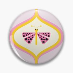 a button with a pink and yellow butterfly on it's back side, against a white background