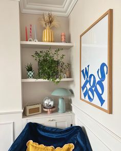 a blue and yellow pillow sitting on top of a bed next to a book shelf