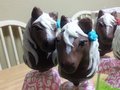 three chocolate horses with white frosting on their heads sitting in front of each other