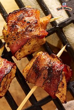 several pieces of meat are being grilled on a grill with skewered toothpicks