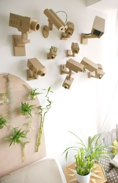 there are many wooden toys hanging on the wall next to a chair and potted plant