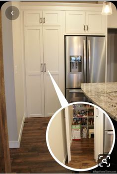 an open refrigerator in a kitchen with white cabinets and wood flooring next to it