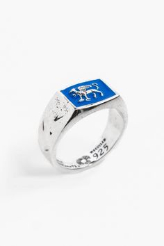 Introducing the Gryphon Ring by Merchants of the Sun, a striking unisex handmade jewelry piece. Crafted with care from 925 recycled sterling silver, this gryphon ring features a captivating design. The addition of blue enamel detailing adds a vibrant touch and makes a bold statement. Elevate your style with the Gryphon Ring, a symbol of exceptional craftsmanship and individuality. Known as a guardian of treasure and a mouthpiece for the sun, the Gryphon epitomises a level of invincible enthusias Sterling Silver White Gold Enamel Ring With Polished Finish, Polished Sterling Silver Enamel Ring In White Gold, Polished White Gold Enamel Ring In Sterling Silver, White Gold Enamel Ring With Polished Sterling Silver, Silver Open Ring With Enamel, Hallmarked Silver Enamel Sterling Silver Ring, Hallmarked Silver Enamel Ring In Sterling Silver, Handmade Blue Sterling Silver Signet Ring, Blue Sterling Silver Engraved Signet Ring