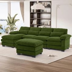 a living room with a large green sectional couch and matching footstool in front of a bookshelf