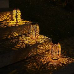 two vases sitting on top of cement steps with light shining through the shadows from them