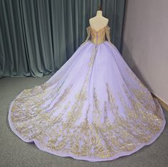 Experience ultimate luxury with our exquisite Princess Purple and Gold Quinceañera Ball Gown. This regal dress boasts a sweetheart front bodice and a gold-trimmed illusion corset, adorned with off-the-shoulder beaded gold long sleeves. The gathered full skirt is elegantly trimmed in gold and features a train, while the lace-up back allows for a customizable fit. Elevate your event with this exclusive and sophisticated masterpiece. material: organza, glitter tulle, lace type: a line ball gown style: formals color as shown built in bra sweetheart neckline train as shown lace up back Purple And Gold Dress Gowns, Gold And Purple Uince Dress, Purple Quinceanera Dress With Sweep Train, Luxury Purple Quinceanera Dress With Sweetheart Neckline, Luxury Purple Tulle Quinceanera Dress, Wedding Veil Blusher, Prom Tiaras, Bridal Hair Bands, Elbow Length Veil