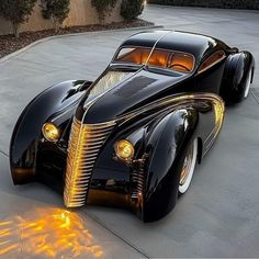 a black car with yellow lights on it's hood parked in front of a building