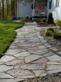 a stone walkway in front of a white house