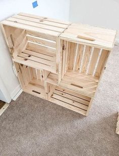 a wooden crate sitting on top of a carpeted floor next to a white wall