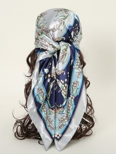 a woman's head wearing a blue and white scarf with flowers on the side