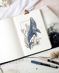 an open notebook with a drawing of a whale on it