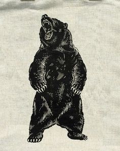 a black and white drawing of a bear on a canvas tote bag with the words,