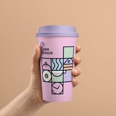 a hand holding a pink coffee cup with an abstract design on the front and side