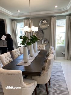 a dining room table with white chairs and a black centerpiece on top of it