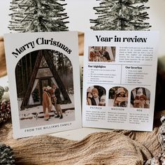 two christmas cards sitting next to each other on top of a wooden table with pine cones