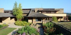 a large house with lots of flowers in front of it