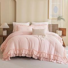 a bed with pink comforter and pillows in a room