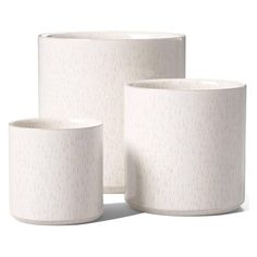 three white vases sitting next to each other