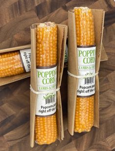 two packages of fresh corn sitting on top of a wooden table