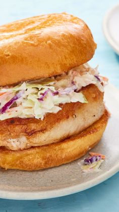 a chicken sandwich with coleslaw on a white plate