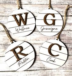 three wooden ornaments with the letters g, v, and g hanging from strings on a wood