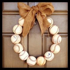 a baseball wreath is hanging on the front door with burlocks and a bow