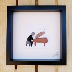 a shadow frame with a dog and cat in it on a wooden table next to a wall