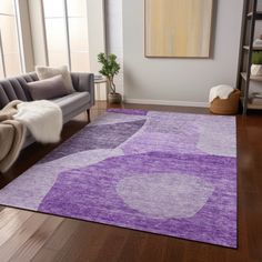 a living room with a purple rug on the floor and a couch in front of it