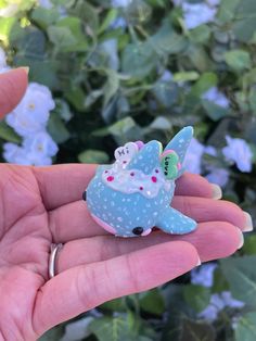 a hand holding a tiny blue toy animal