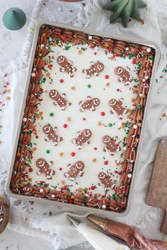 a sheet cake decorated with gingerbreads and sprinkles on a table