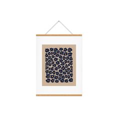 a white frame hanging on a wall with a blue and brown square pattern in it