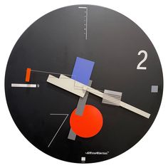 a black clock with red, blue and orange shapes on it