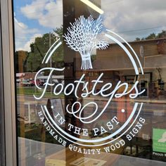 the logo for foot steps in the past is etched into the glass door that reflects the store's exterior