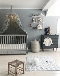 a baby's room is decorated in gray and white, with a canopy over the crib