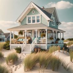 a house on the beach with sand dunes and grass in front, surrounded by sea oats