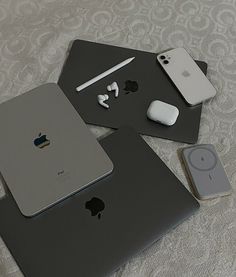 two apple products are sitting on top of each other, one is silver and the other is gray