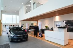 a car is parked in a showroom with people