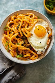 a bowl filled with noodles and an egg on top